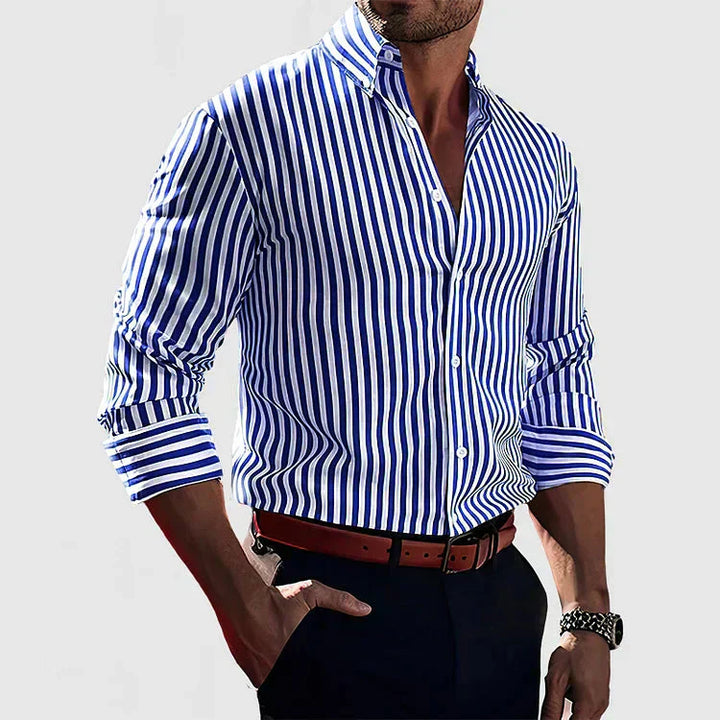 Front view of a man wearing a blue and white striped long sleeve shirt with a brown belt and dark trousers