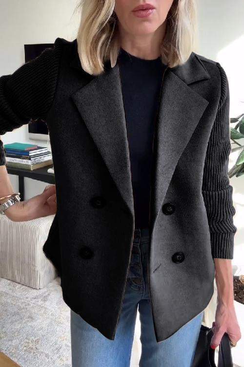 Front view of a model wearing the black button patchwork sleeve casual coat over a black top and blue jeans