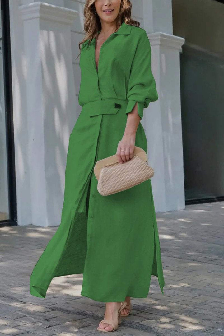 Front view of a model wearing a green solid colour maxi shirt dress with an adjustable waist and a clutch bag