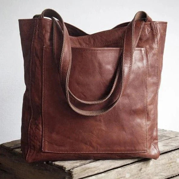 Three quarter view of the Josie leather handbag in tan with a large external pocket and twin shoulder straps