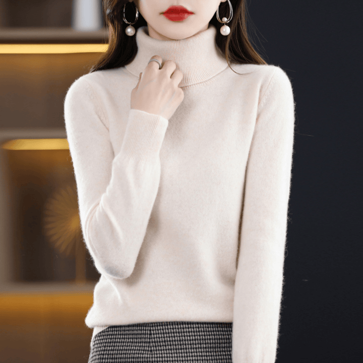Front view of a woman wearing a white 100% cashmere turtleneck jumper with pearl earrings and a silver ring