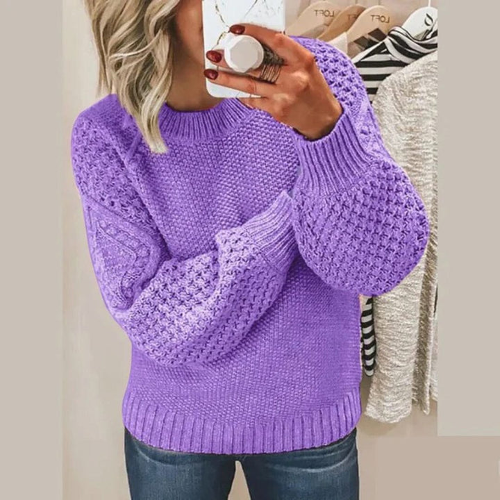 Front view of a woman taking a mirror selfie wearing the Aria soft cotton jumper in purple with textured sleeves