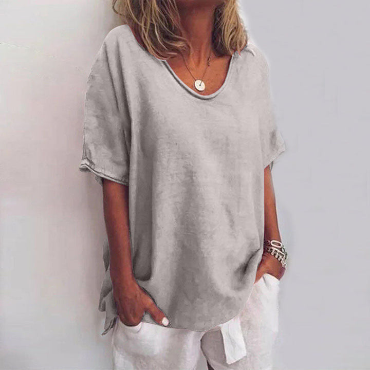 Front view of a model wearing a grey relaxed comfort shirt with a scooped neckline and short sleeves