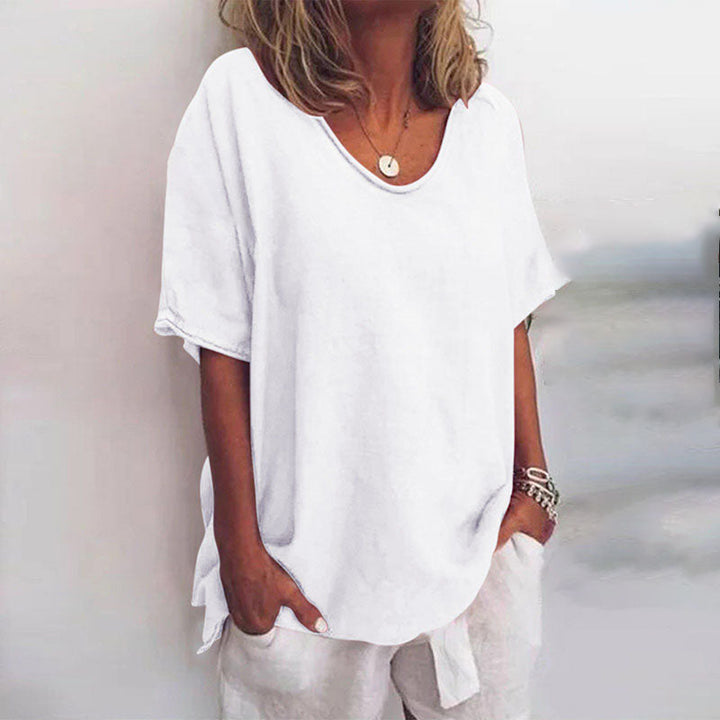 Front view of a model wearing a white relaxed comfort shirt with a scooped neckline and short sleeves