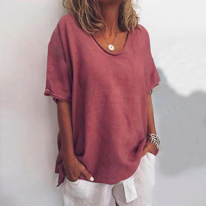 Front view of a model wearing a relaxed comfort shirt in dusty pink with a scooped neckline and short sleeves