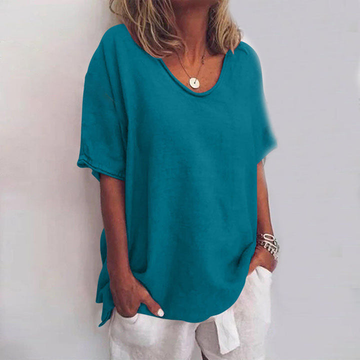 Front view of a model wearing a teal relaxed comfort shirt with a scooped neckline and short sleeves