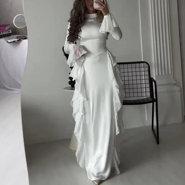 Side view of a model wearing the white elegant patchwork maxi dress with bell sleeves and cascading ruffles