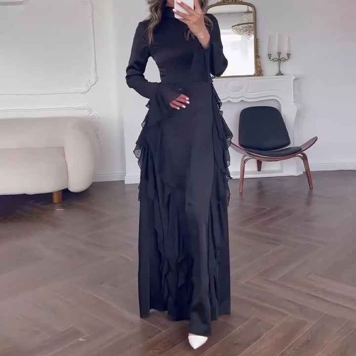 Front view of a model wearing the black elegant patchwork maxi dress with bell sleeves and ruffled skirt layers