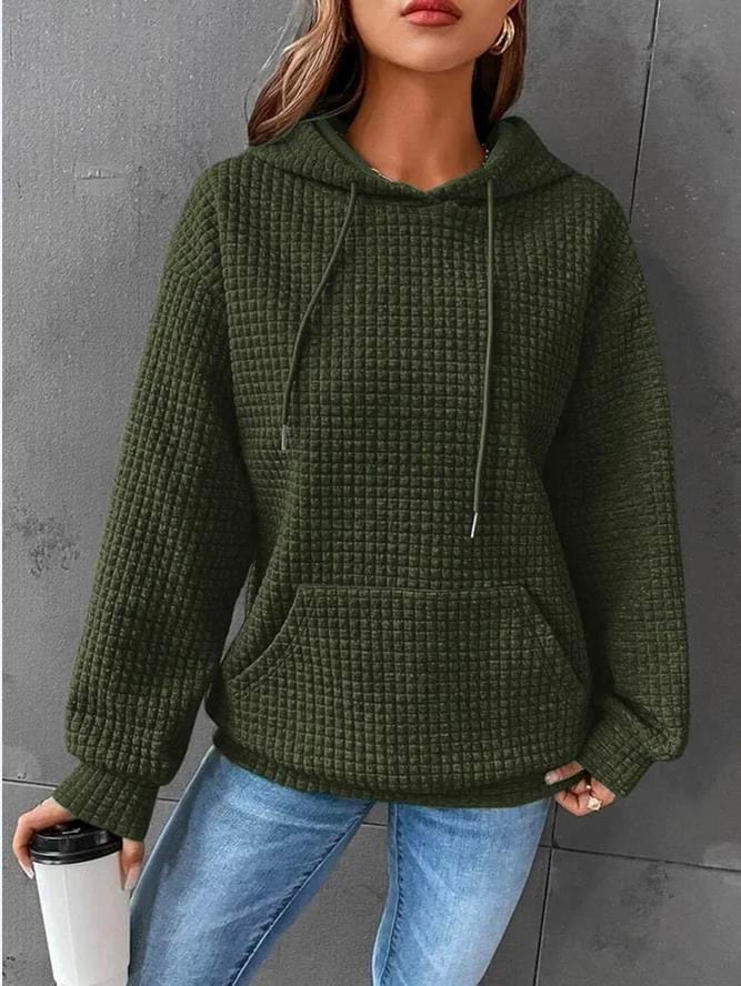 Front view of a model wearing the olive green oversized cotton hoodie with waffle texture, drawstring, and front pocket