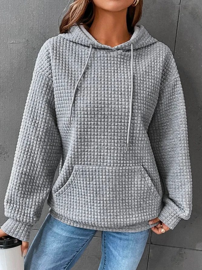 Front view of a model wearing the grey oversized cotton hoodie with waffle texture and front pocket