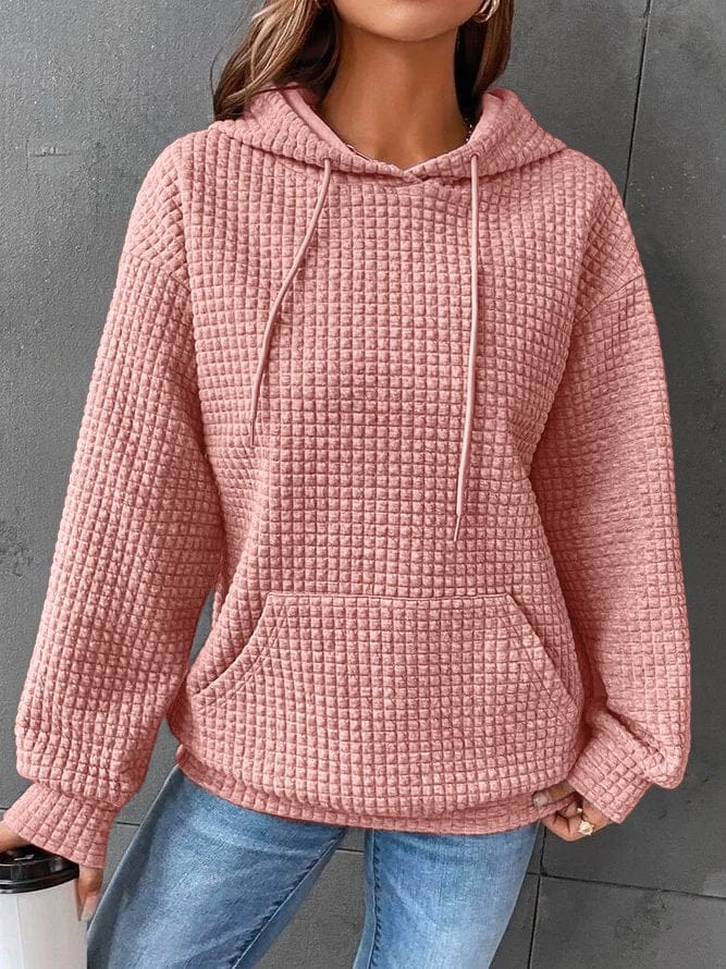 Front view of a model wearing the pink oversized cotton hoodie with waffle texture, drawstring, and front pocket