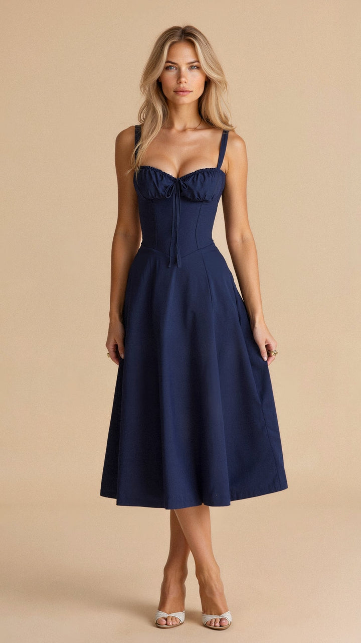 Front view, model wearing a navy blue waist-emphasising bustier dress with a sweetheart neckline, on a beige background
