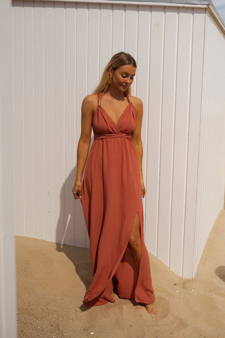 Front view of a model wearing a multi-wear V-neck summer maxi dress in a terracotta shade with a high leg split