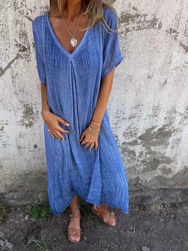 Front view of a model wearing the elegant midi V-neck summer dress in a lovely blue, with hands on the dress