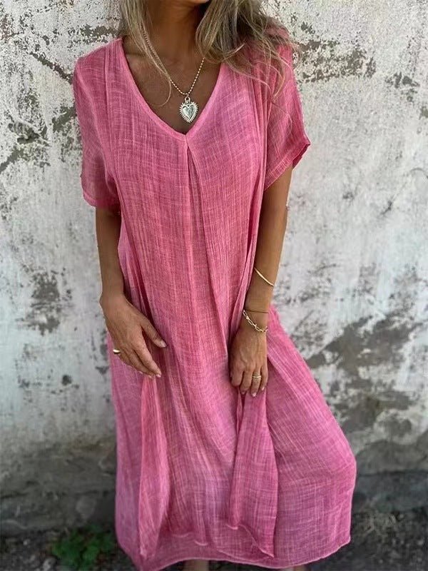 Front view of a model wearing the elegant midi V-neck summer dress in peach, with hands resting by her sides