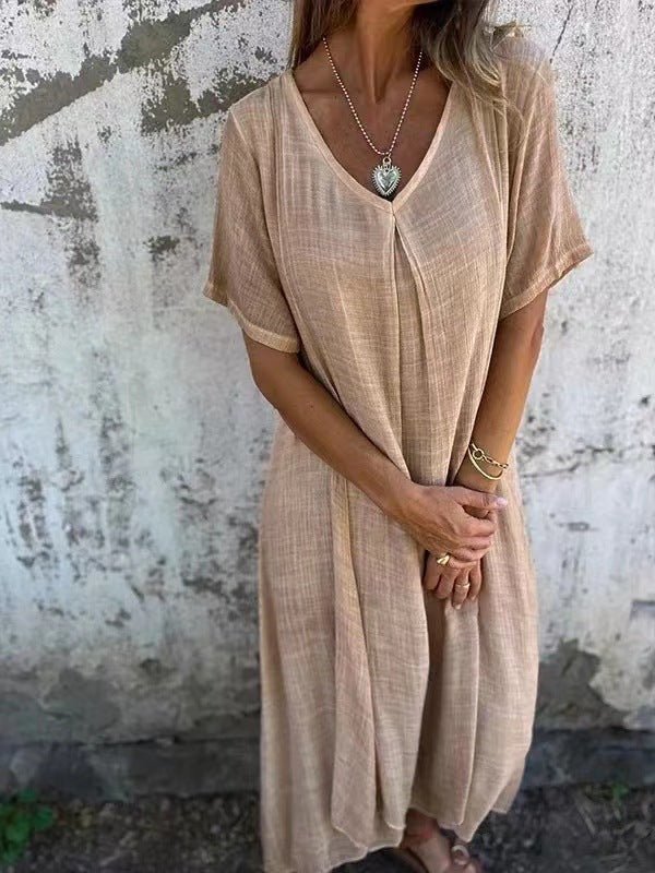 Light beige V neck midi summer dress worn with a pendant necklace