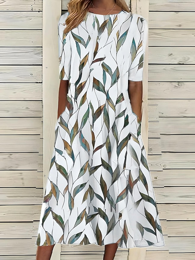 Worn by model, a Kust Flower Dress with a white background and green and brown leaf pattern