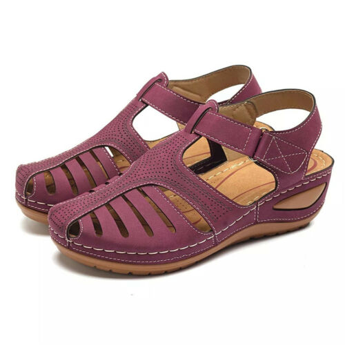 Front three quarter view of a pair of purple orthopedic summer sandals with cutouts and white stitching