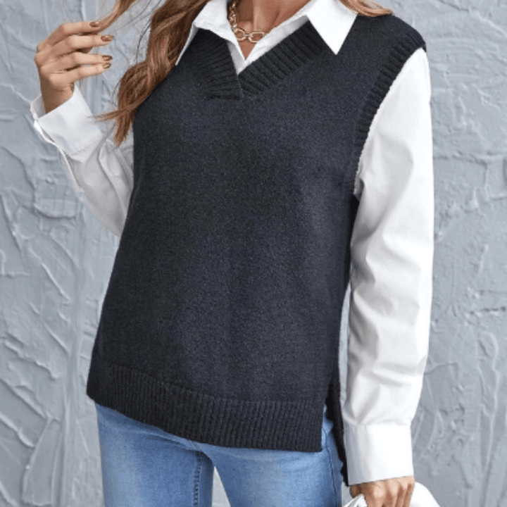 Front view of a model wearing a dark grey V-neck knit sweater vest over a white collared shirt and blue jeans