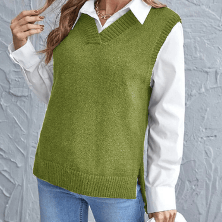 Front view of a model wearing an olive V-neck knit sweater vest over a white collared shirt and blue jeans