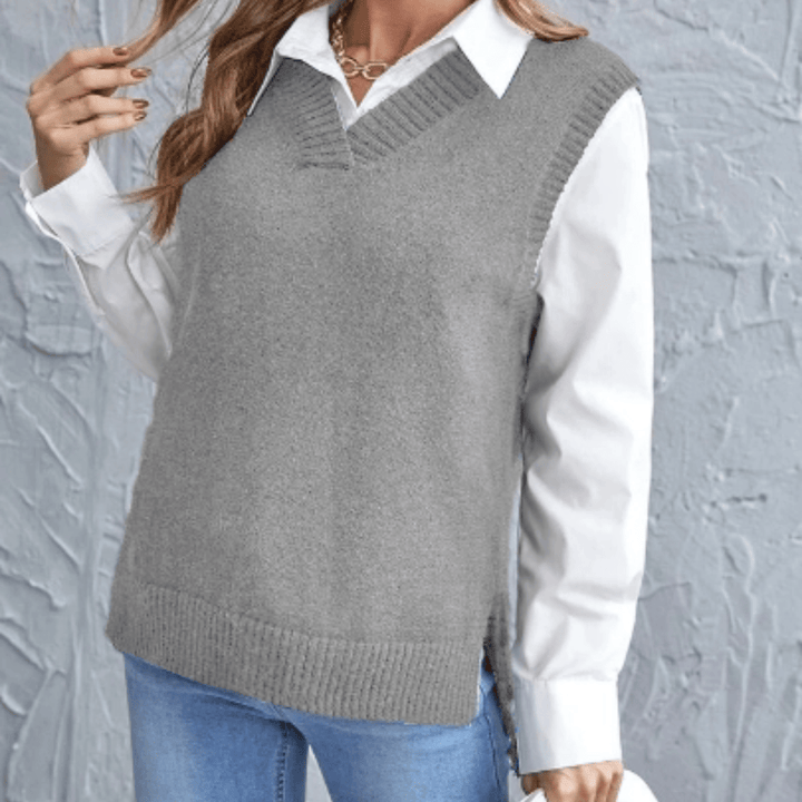 Side view of a model wearing a grey V-neck knit sweater vest over a white collared shirt and blue jeans