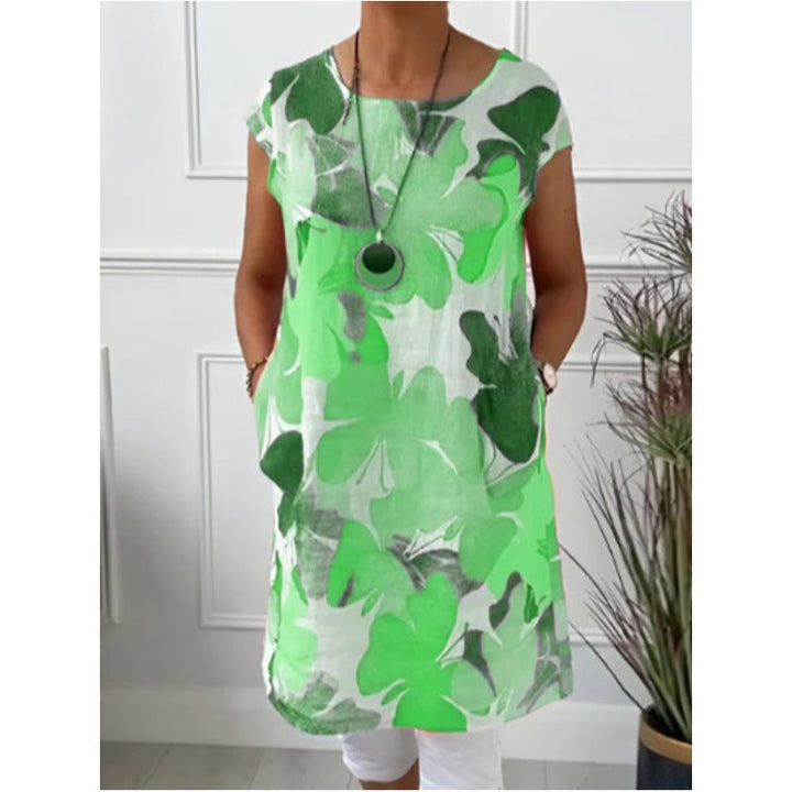 Front view of the elegant shirt dress, featuring a green floral print and side pockets, worn by a model