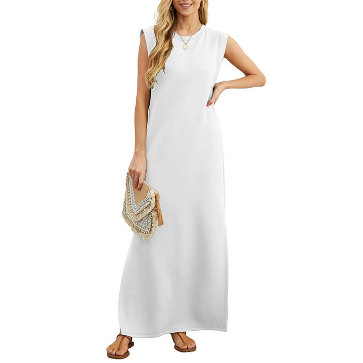Front view of a model wearing a white crease-resistant maxi dress with a side slit and brown sandals