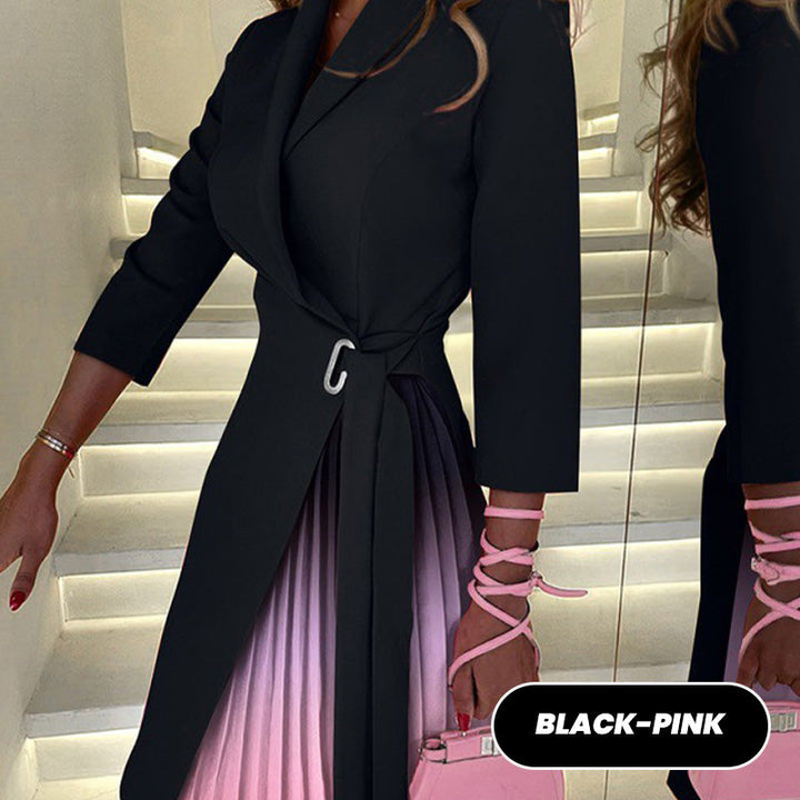 Close up of a model wearing a black pleated blazer dress with a pink pleated skirt and silver buckle