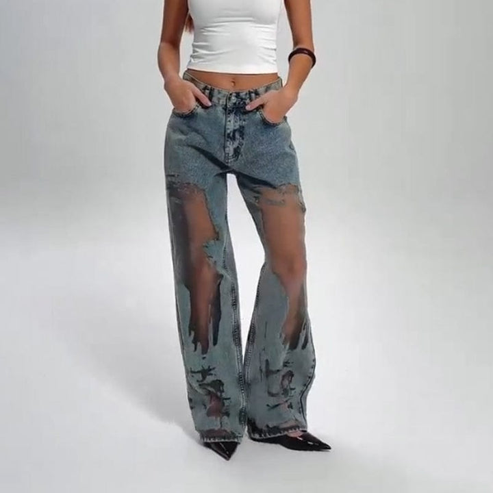Front view of a model wearing See-Through Patchwork Wide Leg Jeans with distressed details and black pointed heels