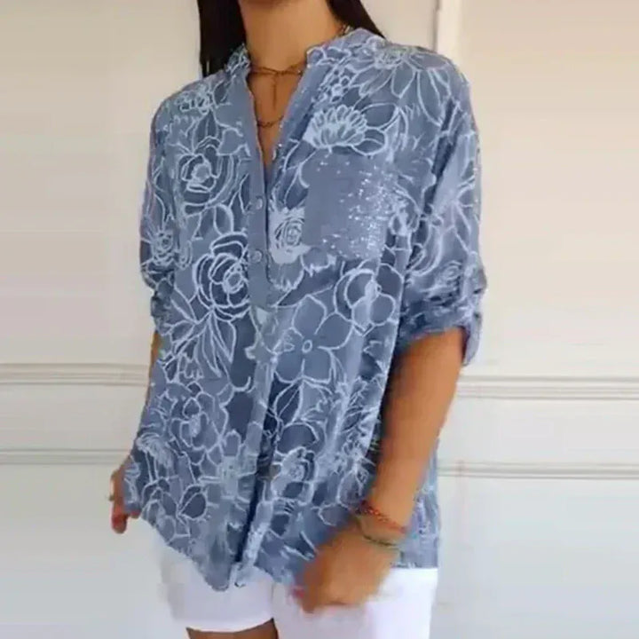 Dusty blue floral V neck blouse with white shorts and a gold necklace