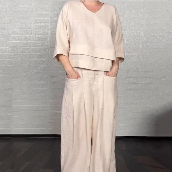 Front view worn by model, beige V-neck jumpsuit with wide-leg pants and hands in pockets