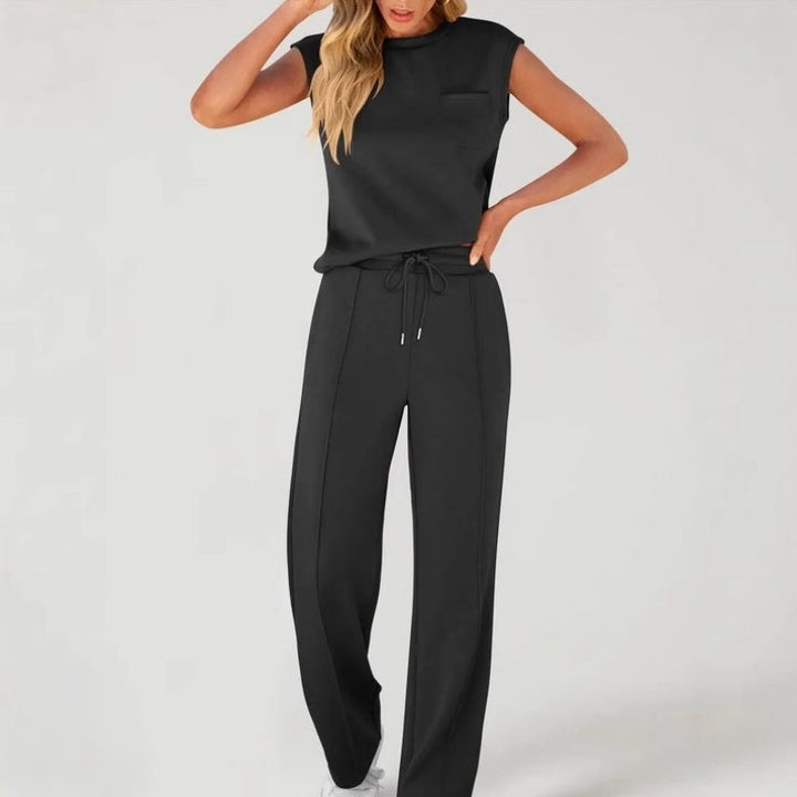 Front view worn by model, black sleeveless top with chest pocket and drawstring pants set