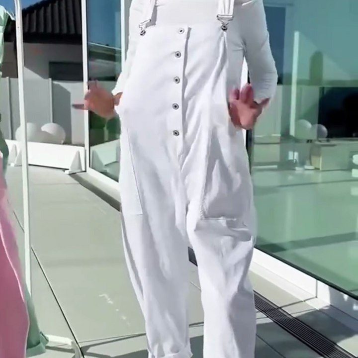 Side view of a model wearing soft pantyhose with straps under white overalls