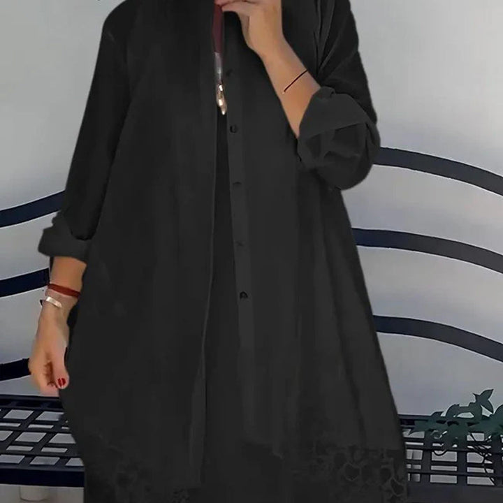 Close up of a model wearing a black sleeveless dress with a black lace vest set, showing lace detail on hem