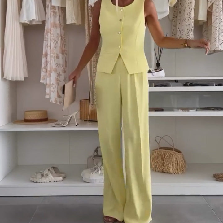 Front view, model wearing a yellow sleeveless top and tailored long pants set in a walk-in wardrobe