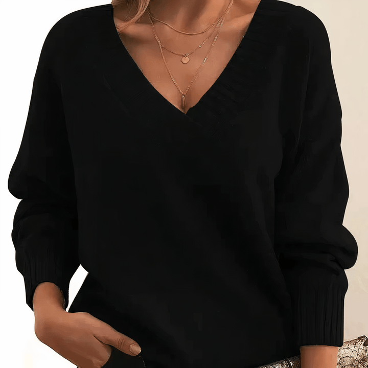 Black V neck knit jumper with layered gold necklaces, front view