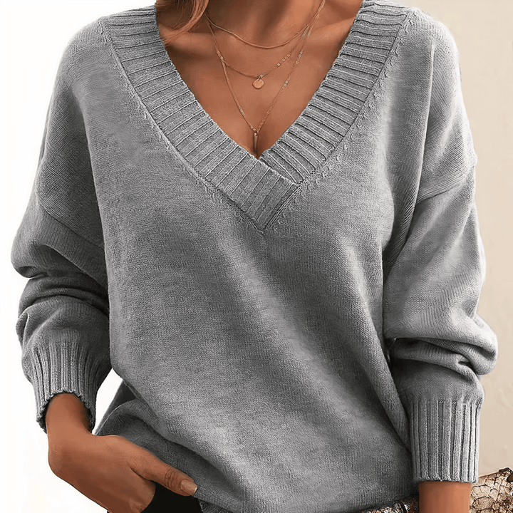 Light grey V neck knit jumper, close up of layered gold necklaces