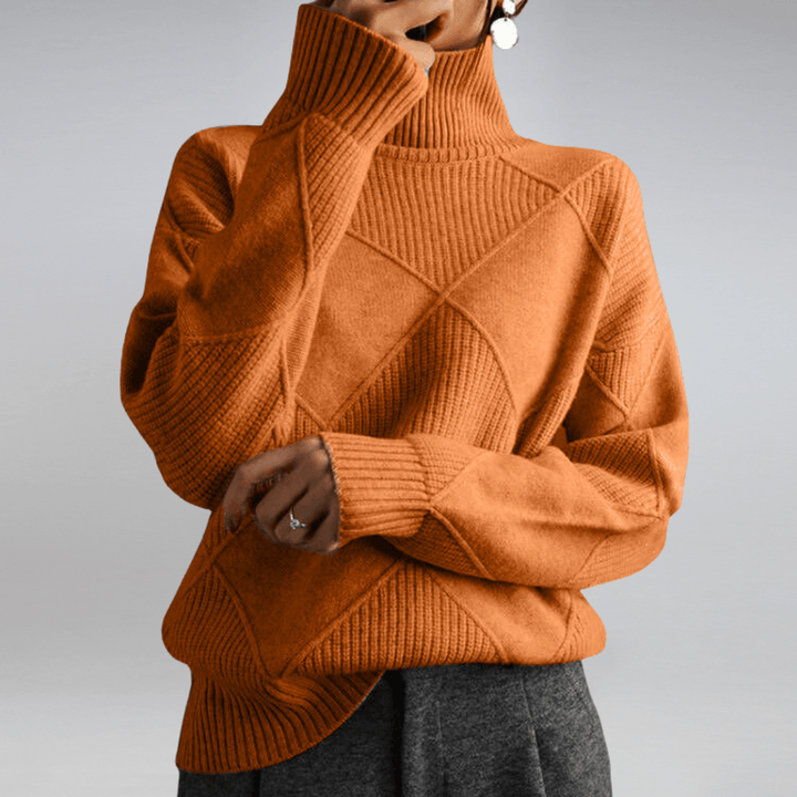 Front view of a model wearing an orange check turtleneck knit sweater with textured diamond patterns