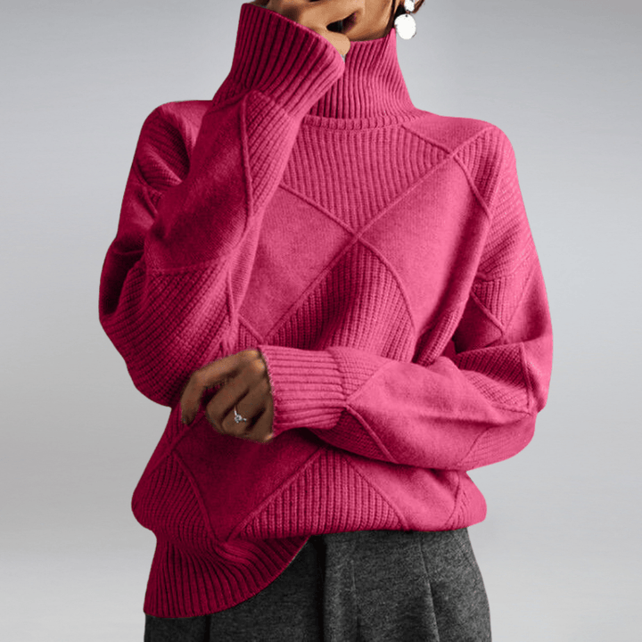 Front view of a model wearing a pink check turtleneck knit sweater with textured diamond patterns