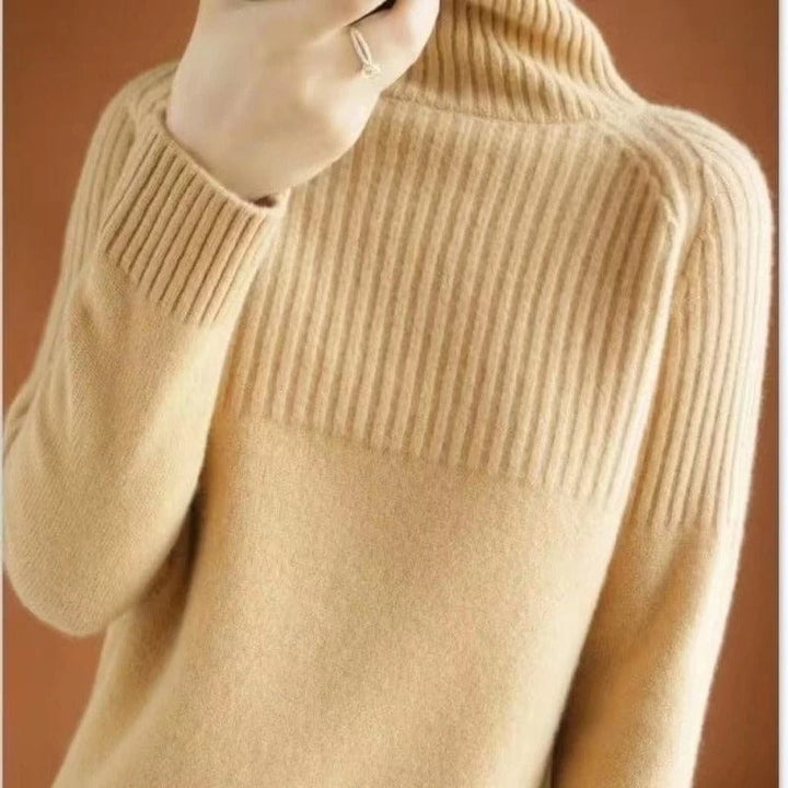 Back view of a model wearing a soft beige ribbed turtleneck jumper with a ring on her finger