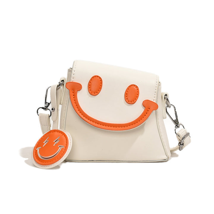 Front view of a white Bright Smile crossbody bag with orange smiley face and keyring against a white background