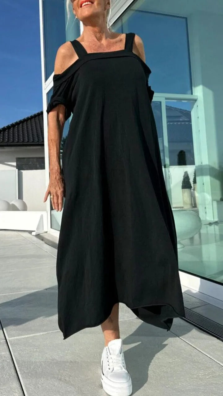 Front view, model wearing a black Brianna maxi dress with open shoulders and white platform sneakers