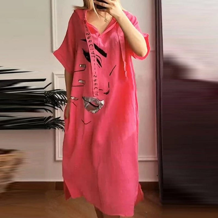 Front view of a model wearing a pink retro abstract hooded dress with an art-inspired face print and pockets