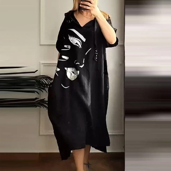 Front view of a model wearing a black retro abstract hooded dress with an art-inspired face print and pockets