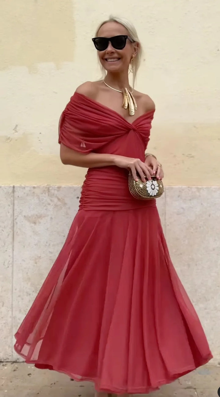Front view, worn by model, of the Christi Off-Shoulder V-Neck Printed Dress with black sunglasses and gold earrings