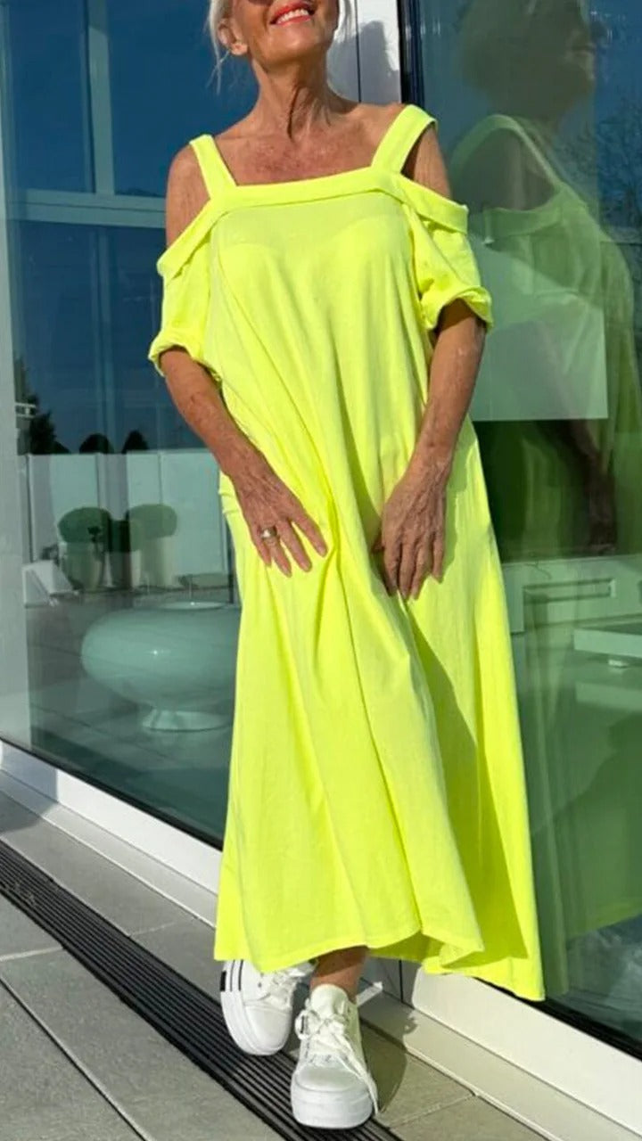 Front view, model wearing a bright yellow Brianna maxi dress with open shoulders and white platform sneakers
