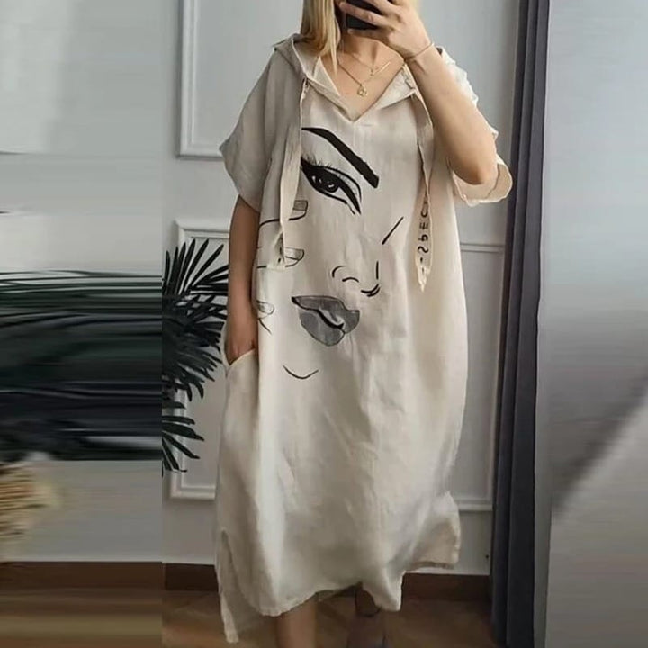 Front view of a model wearing a retro abstract hooded dress with an art-inspired face print and pockets
