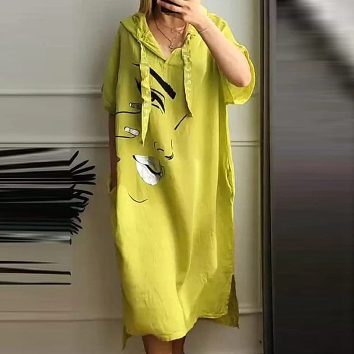 Front view of a model in a lime green retro abstract hooded dress with an art-inspired face print and pockets