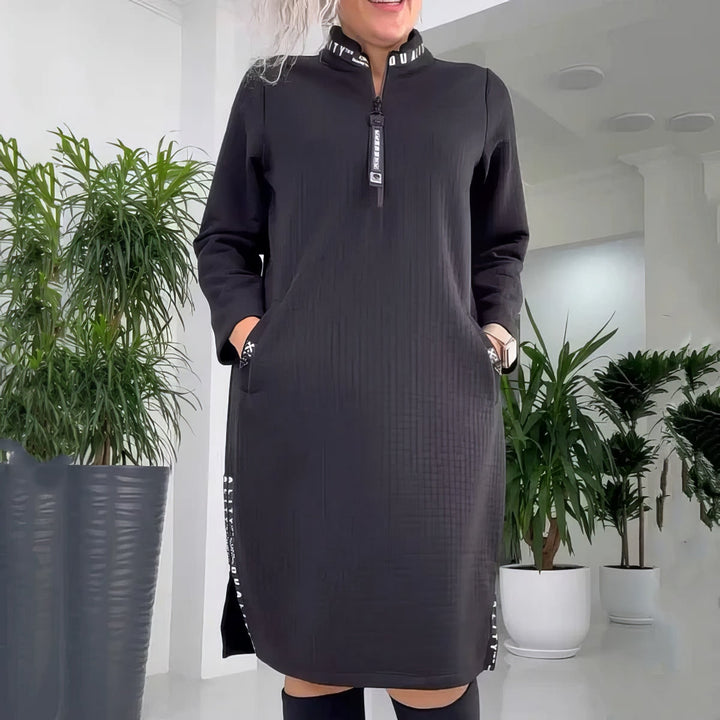 Front view of a model wearing a black casual loose-fit dress with a zip collar and side slit detail