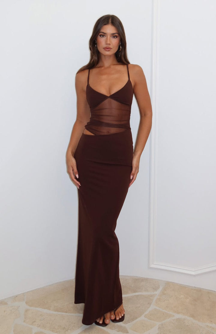 Front view, model wearing a brown sheer mesh maxi dress with a ruched bodice and waist cutout